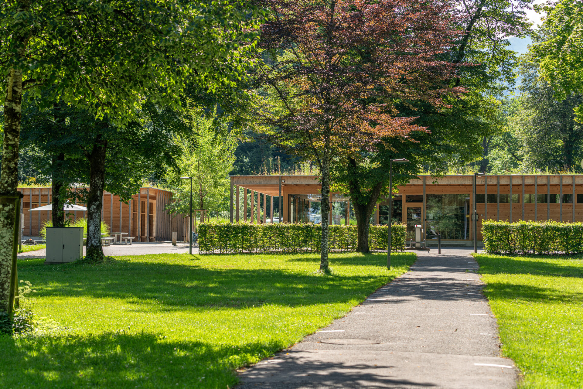 Blick über den Campingplatz, grüne Wiesen und das Restaurant im Hintergrund